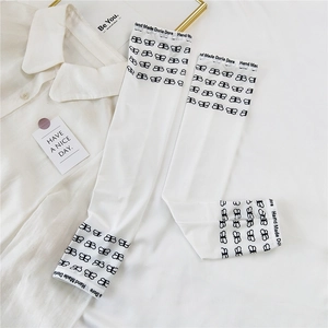 Close-up of white cooling ice silk sun sleeves featuring black butterfly print and thumb holes