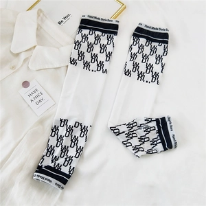 Detail of white cooling arm sleeves with black text branding and geometric patterns