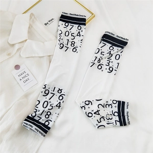 Detail of white cooling arm sleeves featuring black numerical prints and Doria Dore text