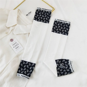 Detail of white cooling arm sleeves with paisley patterns and elastic branded cuffs