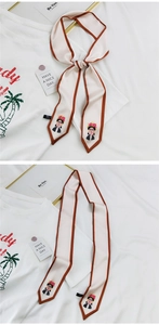 Détail d'un foulard étroit artistique avec imprimé Frida Kahlo sur un t-shirt blanc