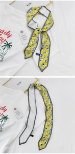 Vue détaillée d'un foulard en soie à motif citron jaune avec bordure grise cousue