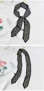 Détail d'un foulard étroit en soie à monogramme K bleu marine et beige noué