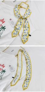 Vue détaillée du foulard twilly fleuri avec texte Love yourself et bordure jaune