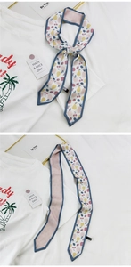 Détail macro d'une écharpe étroite en soie avec motifs de fruits colorés nouée en nœud