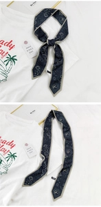 Détail d'un foulard Twilly bleu marine avec motifs astrologiques de soleil et de lune