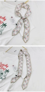 Détail d'un foulard étroit beige avec visage de femme abstrait et imprimés de lèvres