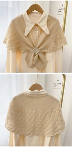 Macro detail of beige knit shawl with hollow crochet pattern and front ribbon bow design