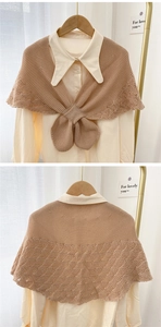 Detail of khaki hollow knit shawl featuring wave pattern lace and bow buckle fastener
