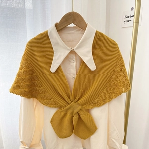 Ginger yellow hollow knit shawl cape with front knot over a white collared shirt