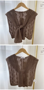Detailansicht eines dunkelbraunen Strickschals mit Wellenmuster und hello doria dore Etikett