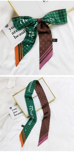 Détail d'un foulard en soie avec motifs pied-de-poule et pois pour coiffure noeud