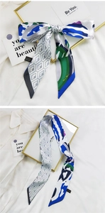 Détail d'un foulard en soie imprimé avec motifs géométriques bleus et verts