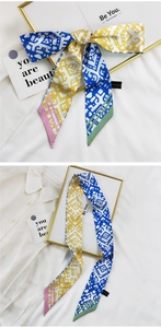 Détail d'un foulard en soie géométrique noué en nœud aux motifs bleu et jaune