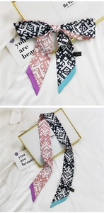 Détail macro du foulard en soie française avec motifs géométriques et bouts contrastés