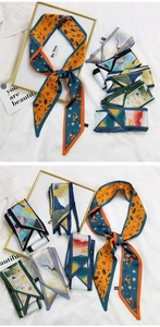 Détail de divers foulards en soie imprimés sur tissu blanc avec cartes décoratives