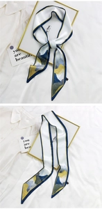 Détail d'un foulard en soie avec bordure bleue et citation 'Be You' sur fond blanc