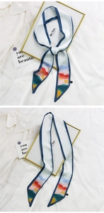 Détail d'un foulard en soie blanche avec liseré bleu et slogan Be You sur une chemise