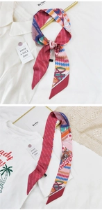 Détail d'un foulard étroit rose rouge avec imprimés mode et motifs élégants