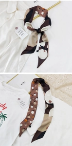 Détail d'un long foulard en soie avec imprimé de fruits d'automne et pointes en biseau