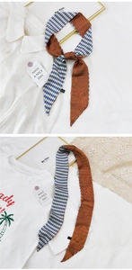 Détail d'un foulard twilly mince avec motif losange bleu et imprimé d'art orange