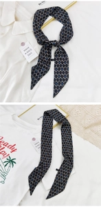 Détail de l'élégant foulard en soie bleu marine avec imprimé chaîne blanc et doré