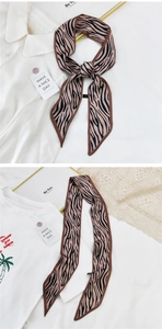 Détail d'un foulard mince en soie à motif zébré avec finition satinée et bords fins