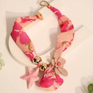 Détail d'un collier bohème en tissu floral avec pendentif étoile de mer et fleur beige