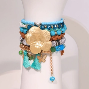 Bohemian multilayer bracelet set featuring blue beads, gold flower and tassel charms