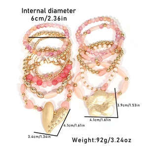 Détail de l'ensemble de bracelets en perles roses et dorées avec breloques cœur et fleurs