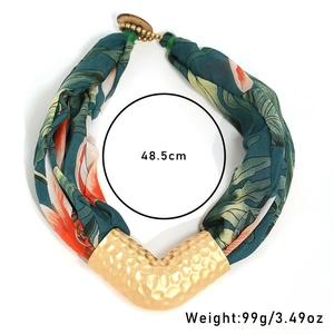 Detail view of tropical palm print fabric necklace with gold-tone hammer texture metal tube