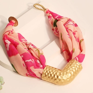 Detail of silk scarf necklace with pink floral pattern and hammered gold pendant