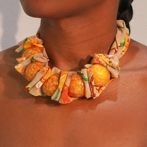 Collier bohème fait main avec grandes perles orange et détails en tissu à fleurs
