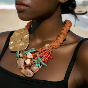 Chunky nautical rope necklace with gold starfish, red coral and shells on beach model