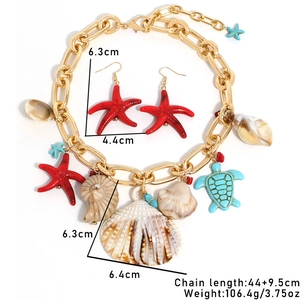 Detailed view of ocean style gold necklace with starfish shells and turtle charms