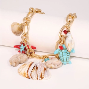 Detailed close-up of a golden charm necklace with a red starfish and sea turtle pendants