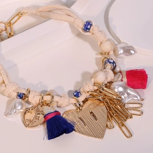 Bohemian woven heart pendant necklace with tassels and baroque pearl on white display