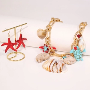 Detail of nautical jewelry set with starfish earrings and sea shell charm bracelet