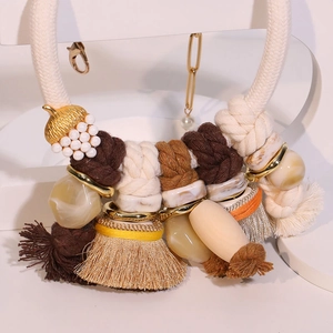 Bohemian woven fringe necklace with marble resin beads and golden acorn pendant detail
