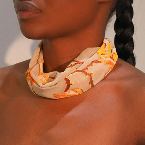Detail of bohemian printed chiffon neck scarf with warm orange floral patterns