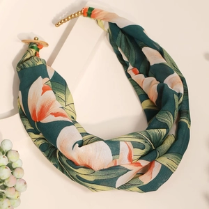 Detail of bohemian floral print fabric necklace with metal beads and wooden buckle accents