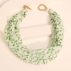 Detail of fabric scarf necklace with green hearts and golden toggle clasp on white stand