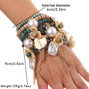 Détail d'un bracelet bohème multicouche avec perles, fleurs en résine et breloques