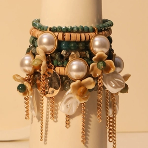 Bracelet multicouche avec fleurs, perles fantaisie, pierres vertes et pompons dorés