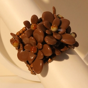 Handmade multi-layer brown flower bracelet with acrylic petals and wood beads on a display