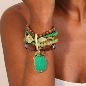 Close-up of bohemian layered beaded bracelet featuring a large green stone pendant