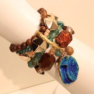 Macro view of multi-layer beaded bracelet set with textured blue stone pendant on display