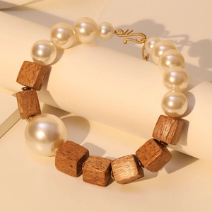 Handmade beaded necklace with white pearls and square wooden beads on a display stand
