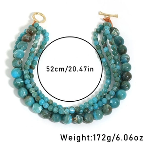 Detail view of multi-layer beaded necklace with turquoise patterns and gold ring clasp