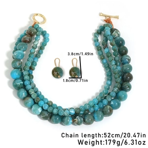 Detail of multi-layered beaded necklace set with marbled blue beads and gold toggle clasp